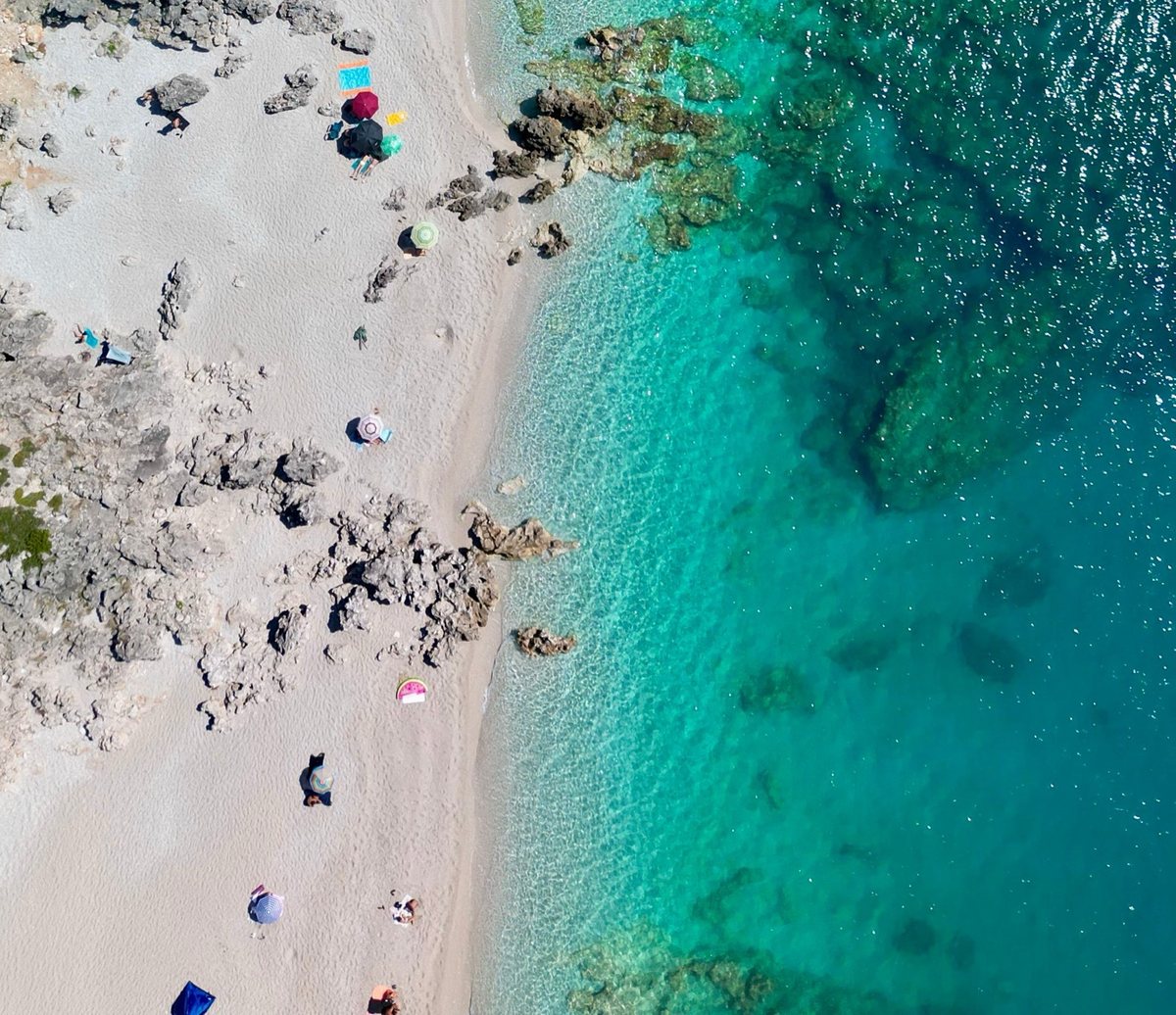 Clear turquoise water along a pebble beach